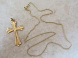 un gros plan d'une croix et d'une chaîne posées sur une table
