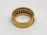 gros plan d'une bague en or sur une surface blanche