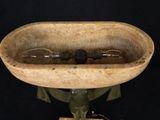 a wooden bowl with a bottle in it on a stand