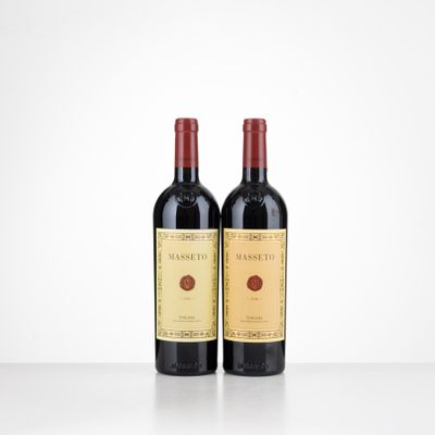 two bottles of red wine sitting on top of a table