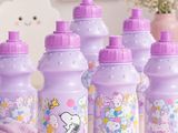 purple bottles with snoop and friends on them sitting on a table