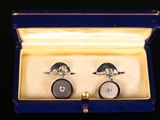 une paire de boutons de manchette dans un coffret posé sur une table