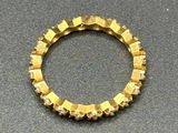 an image of a gold ring on a table with a black background