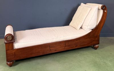 a wooden chaise with pillows on it in a room