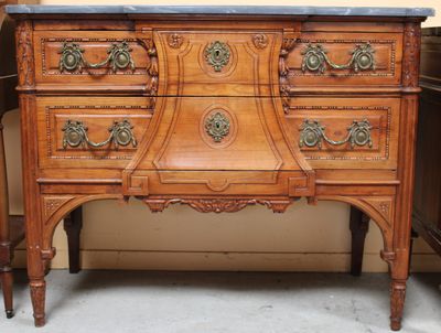 a wooden dresser with a marble top on top of it