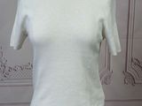 the top of a white shirt is on a mannequin stand