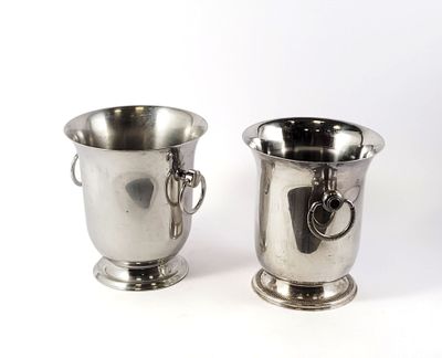 two silver cups sitting next to each other on a white surface