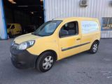 the small yellow van is parked in front of a building