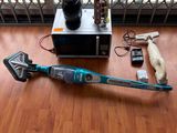un aspirateur sans fil posé par terre près d'une fenêtre