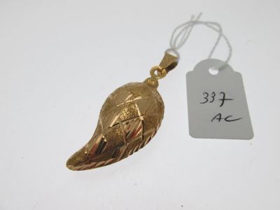 a close up of a gold pendant with a tag on it