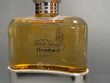 perfume bottle on a silver stand on a gray surface