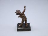 bronze figurine of a boy throwing a frisbee on a marble base