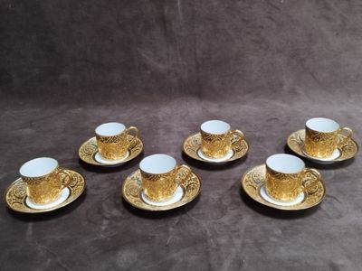 six tasses et soucoupes sont posées sur une table