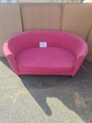 un canapé rose posé devant un mur en carton