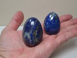 someone is holding two eggs in their hand on a white surface