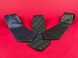 three men ' s neck ties laying on a red surface