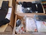 two boxes of clothes and a pair of gloves on the floor