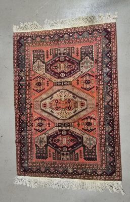 un vieux tapis à franges accroché au mur