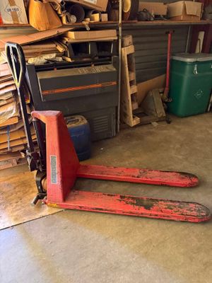 une photo d'un garage avec deux paires de skis posées par terre