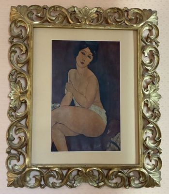 painting of a nude woman in a gold frame on a wall
