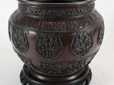 a brown vase that is sitting on a white surface
