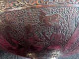 a metal bowl with a design on it on a table
