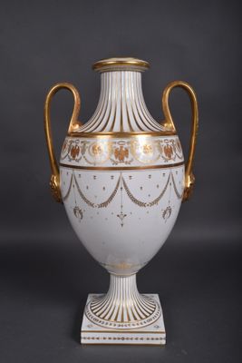 a white vase with gold decoration on it on a black background