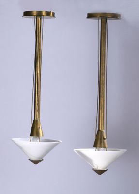 a pair of brass and white glass pendant lights hanging from the ceiling