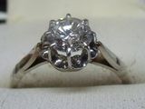 une photo d'une bague en diamant posée sur un tissu blanc