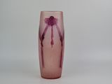 a pink glass vase with a purple flower on it