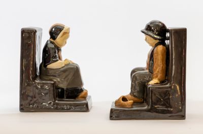 deux figurines représentant une femme assise sur une chaise