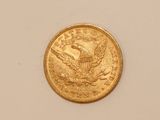 a close up of a gold coin on a white surface