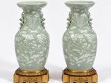 deux vases verts posés sur un socle doré