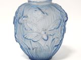 un vase en verre bleu orné d'un motif floral