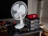 a white fan sitting on top of a table in a room