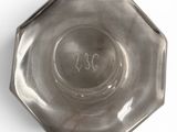 a silver plate with a number on it on a white surface