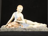 une figurine représentant une femme allongée avec un chat