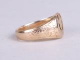 an image of a gold signet ring on a white surface