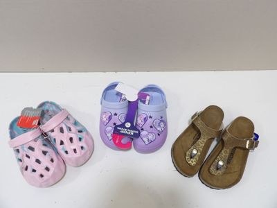 trois paires de chaussures d'enfants posées sur une table