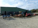 beaucoup de matériel agricole devant un bâtiment vert