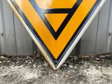 a triangle shaped sign that has been placed on the side of a building