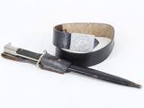 a pen and a leather belt on a white surface