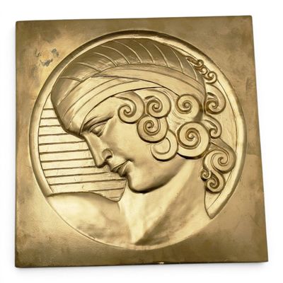 an image of a gold plaque with a woman ' s head on it