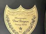 a bottle of champagne sitting on a table next to a glass of wine