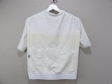 white t - shirt hanging on a hanger against a wall