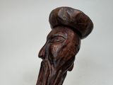 wooden head of an old man with a hat on top of his head