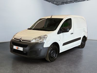 La camionnette blanche est garée dans une grande pièce d'un immeuble.