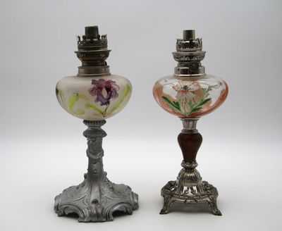 une paire de lampes anciennes en verre posées sur un pied en métal