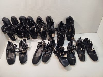 Plusieurs paires de chaussures noires sont alignées sur une étagère blanche