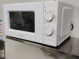 a white microwave sitting on top of a stainless steel counter
